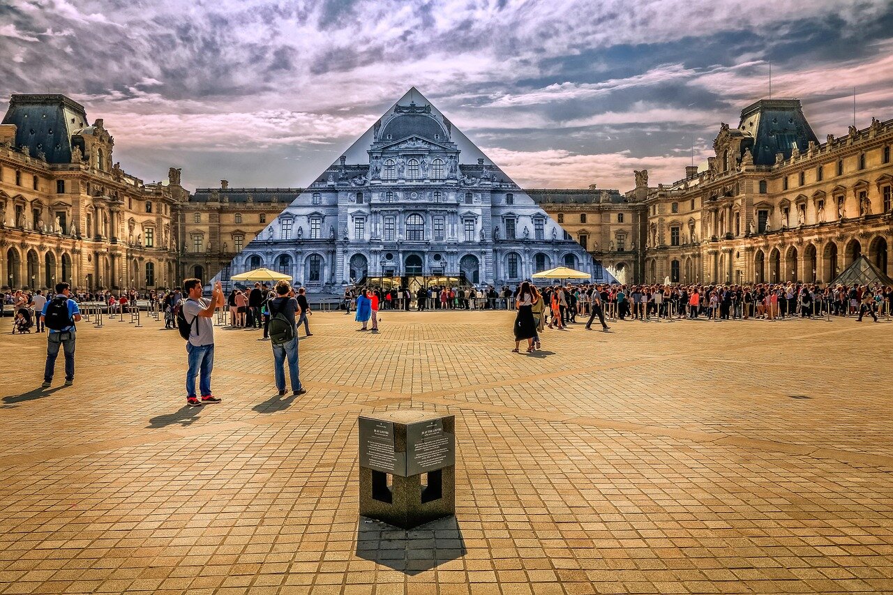 A closeup view of the Louvre Museum's iconic glass pyramid entrance, symbolizing the blend of history and modernity in art and culture