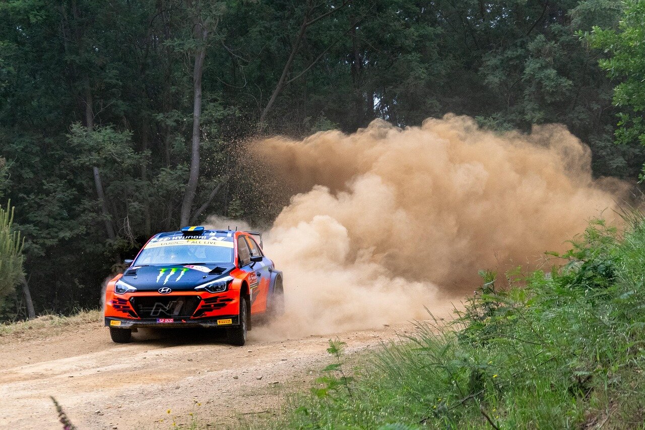 Elfyn Evans celebrating on the podium after a successful rally finish, showcasing his excitement and determination for the sport