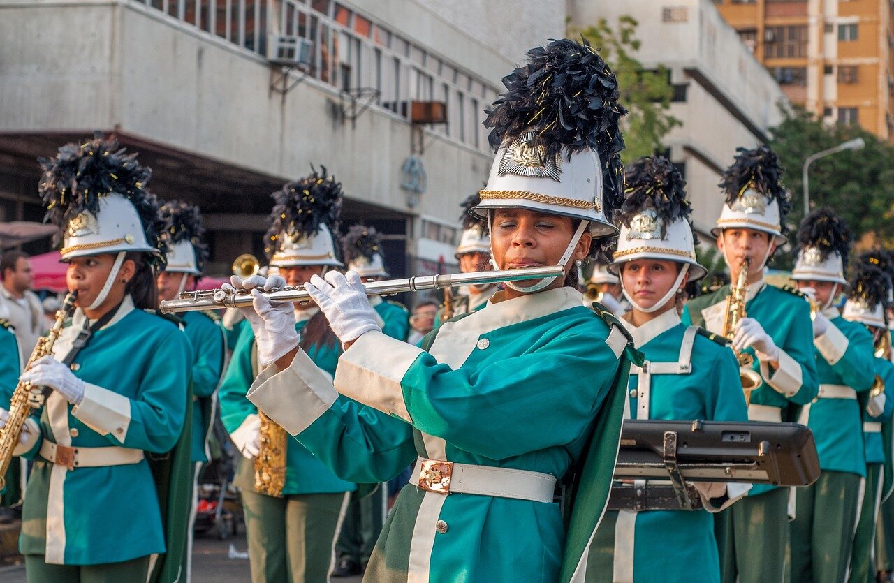 The vibrant atmosphere of the parade reflects the unity and community spirit as Groff and Yang engage with fans, emphasizing the importance of acceptance and love