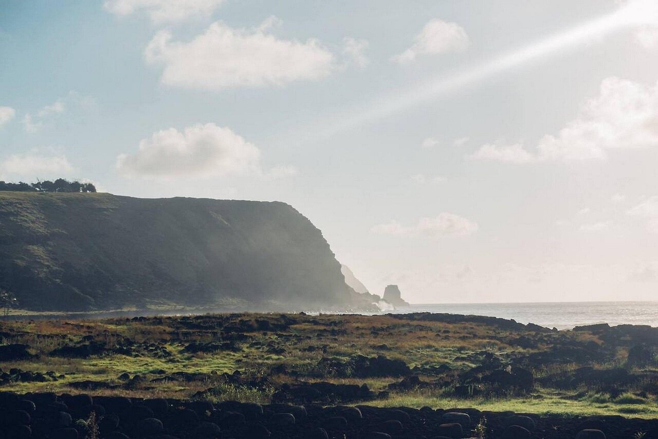 A panoramic landscape of Easter Island, highlighting the location of various Moai statues against the backdrop of the Pacific Ocean