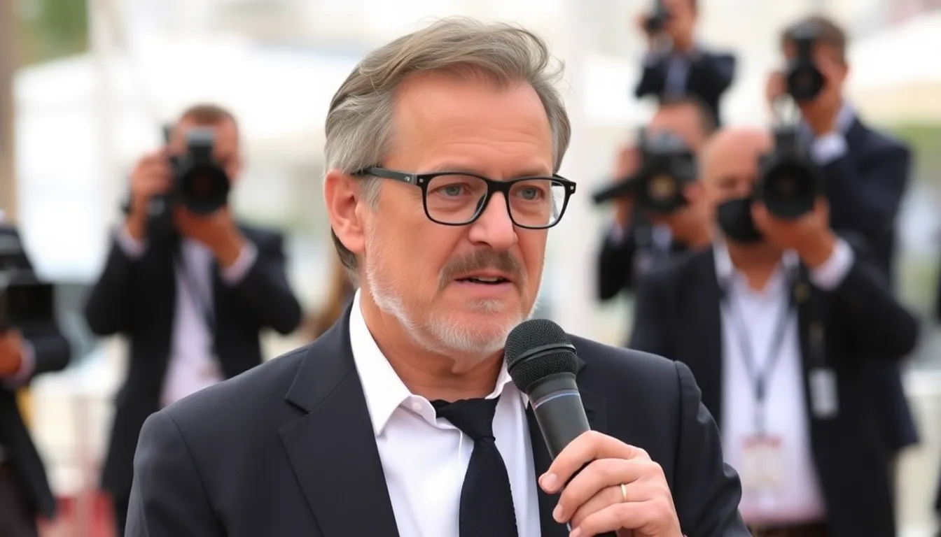 Thierry Fremaux speaks at a press conference, addressing the new Oscars regulations on AI and international films while surrounded by reporters and cameras.