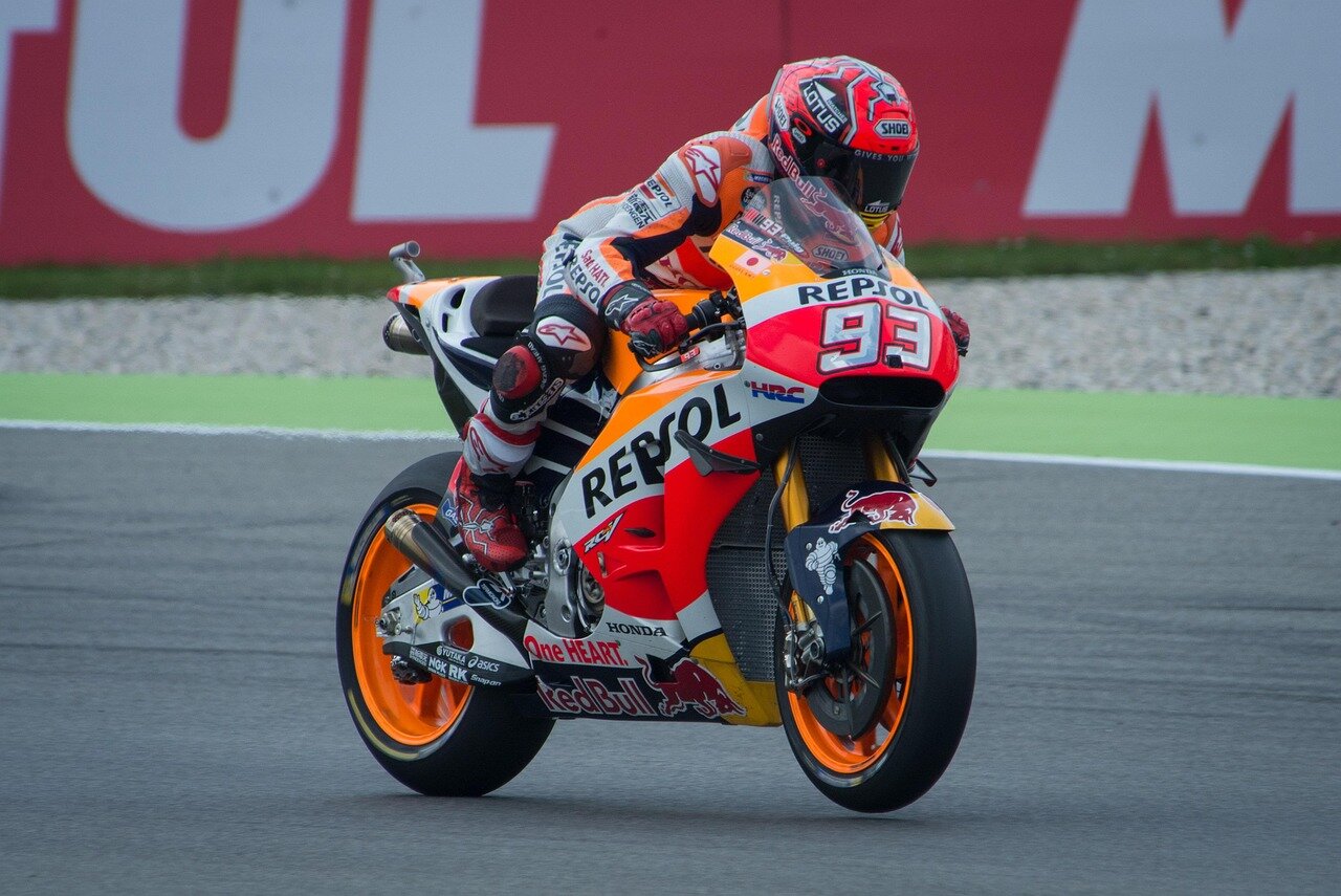 A mechanic finetunes a motorcycle in the paddock, emphasizing the importance of preparation and technical adjustments ahead of the main races