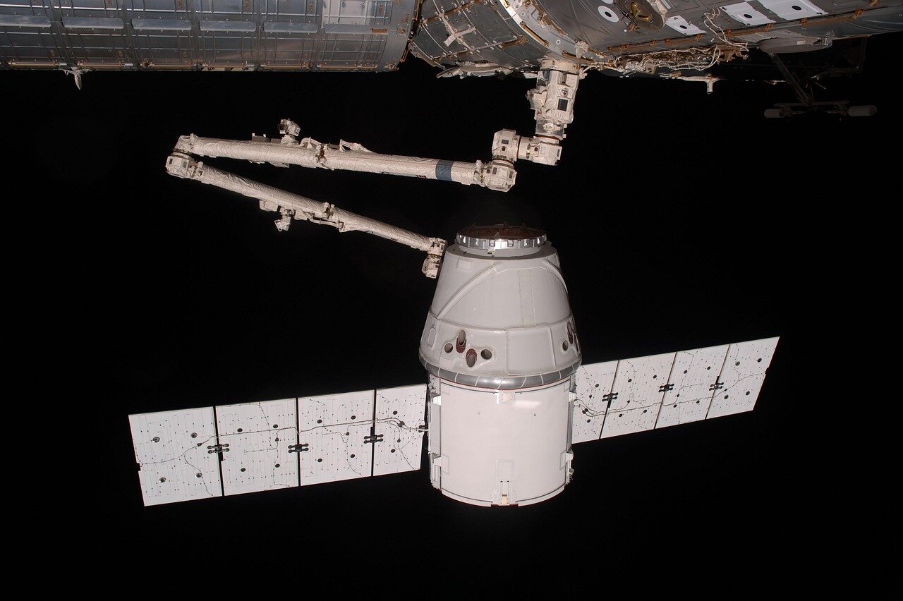 A busy control room filled with monitors displaying data and images from past SpaceX launches, reflecting the company's significant milestones and achievements in space exploration