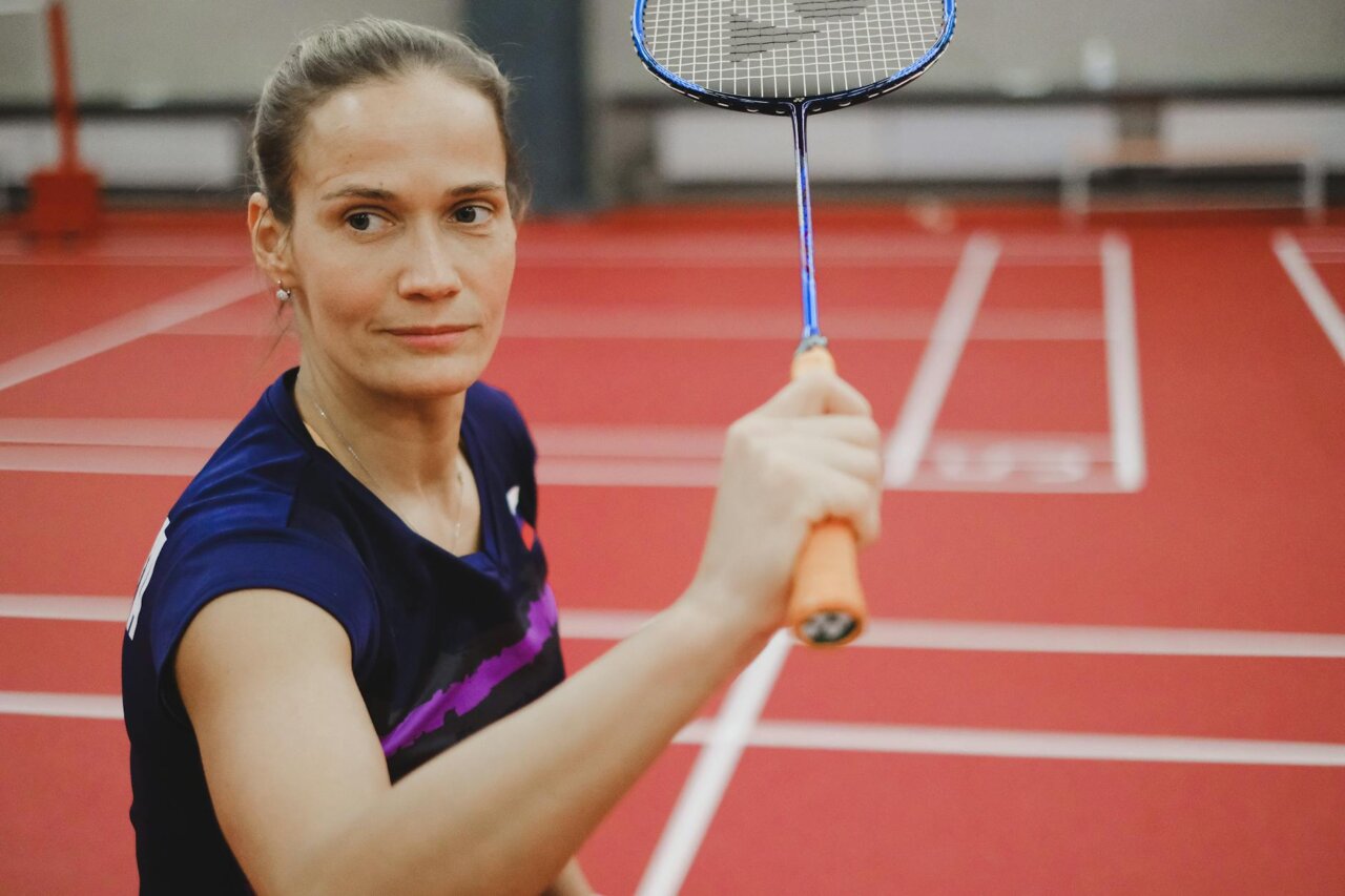 Mirra Andreeva joyfully raises her trophy in celebration after winning the Grand Slam tournament in Paris, surrounded by cheering fans and fellow competitors.