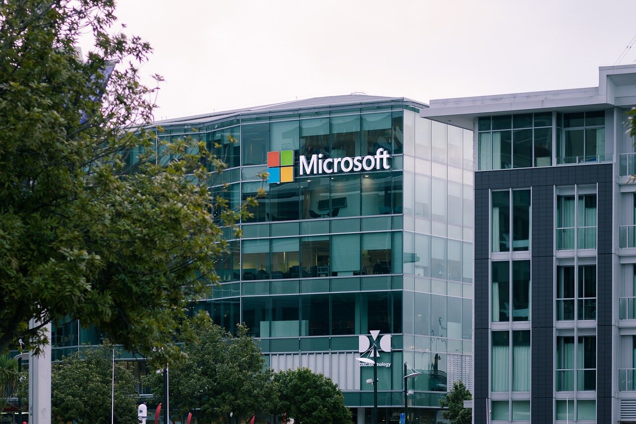 Microsoft executives discuss the potential spinoff of the Xbox gaming division during a strategic meeting in a corporate office.