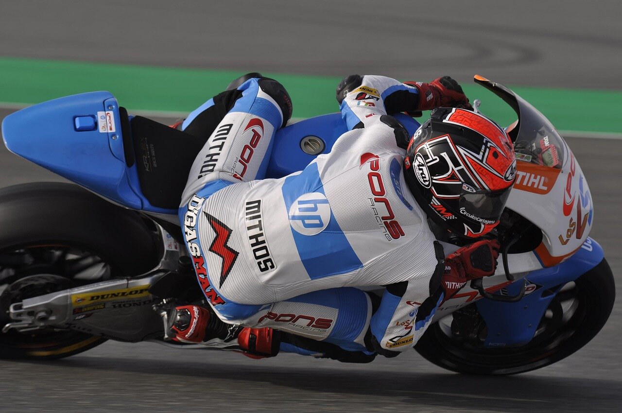 MotoGPの競技場で、レクオナがバイクに跨りレースに向けた意気込みを見せる瞬間