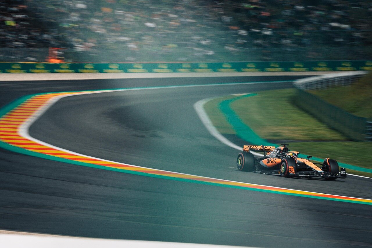 A closeup of Piastri's McLaren car as it speeds past competitors, highlighting the intense competition among drivers on the track