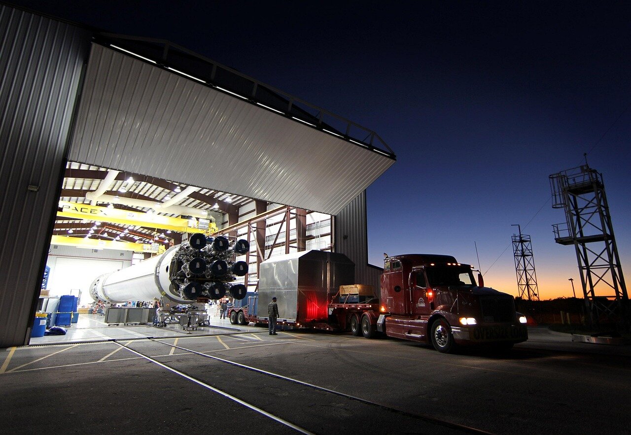 A group of engineers at SpaceX collaborates on a rocket design, surrounded by blueprints and technical equipment in a bustling workspace.