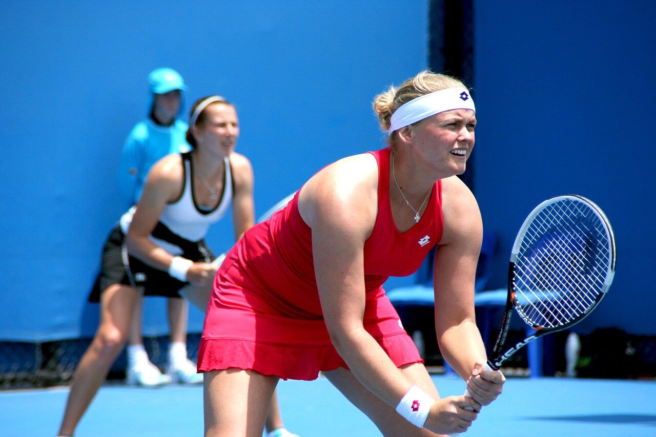 A group of aspiring tennis players sharing a modest accommodation, their determination evident as they discuss strategies and support each other