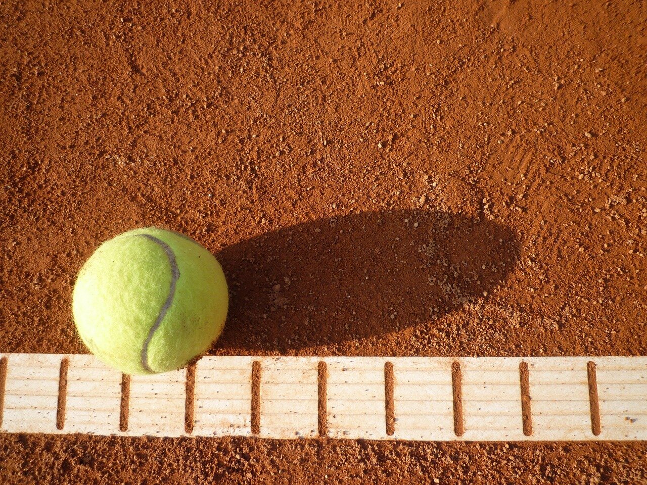 A closeup shot of a player's wornout tennis shoes, symbolizing the physical and financial struggles faced during their journey in the sport