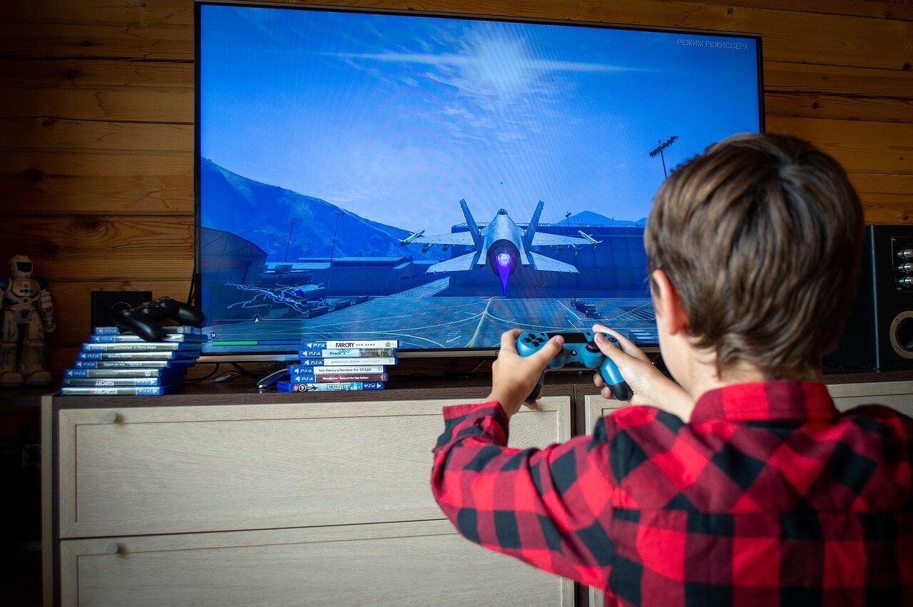 A group of enthusiastic gamers gathers around a large screen, eagerly discussing the latest video game releases while snacks and drinks are spread across a nearby table.