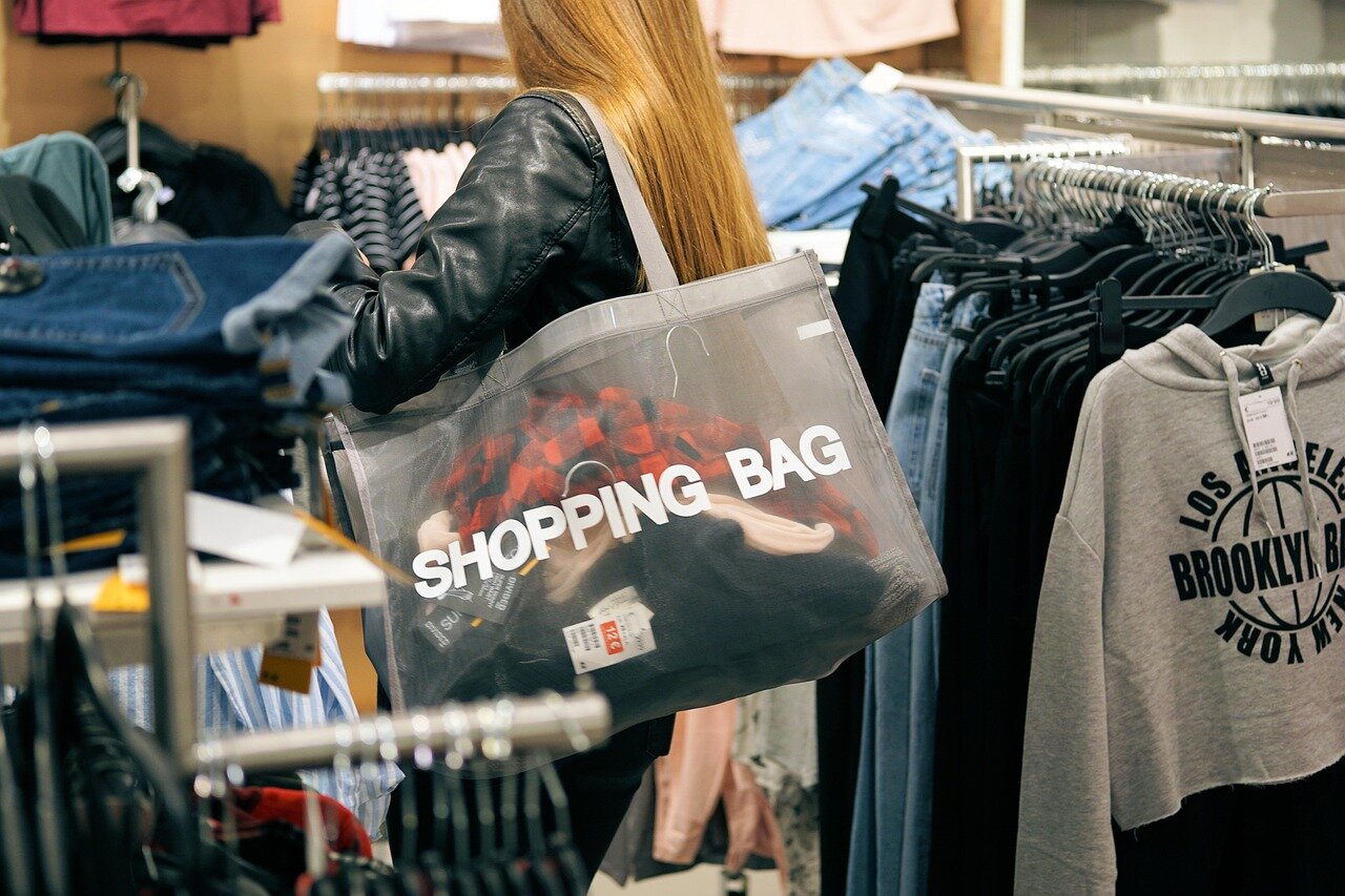 A closeup of a shopping cart filled with discounted summer accessories and clothing items, ready for checkout