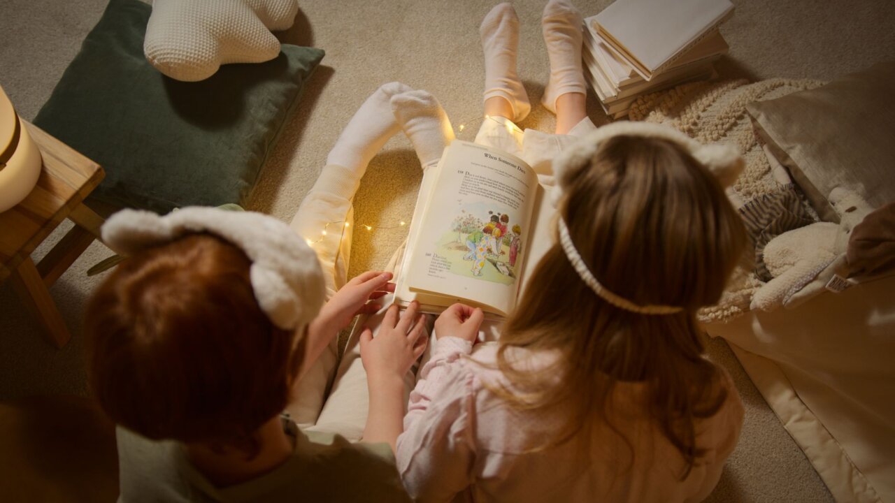 A child joyfully interacts with the Yoto Music Box, surrounded by colorful story cards and a cozy play area, highlighting a screenfree approach to entertainment.