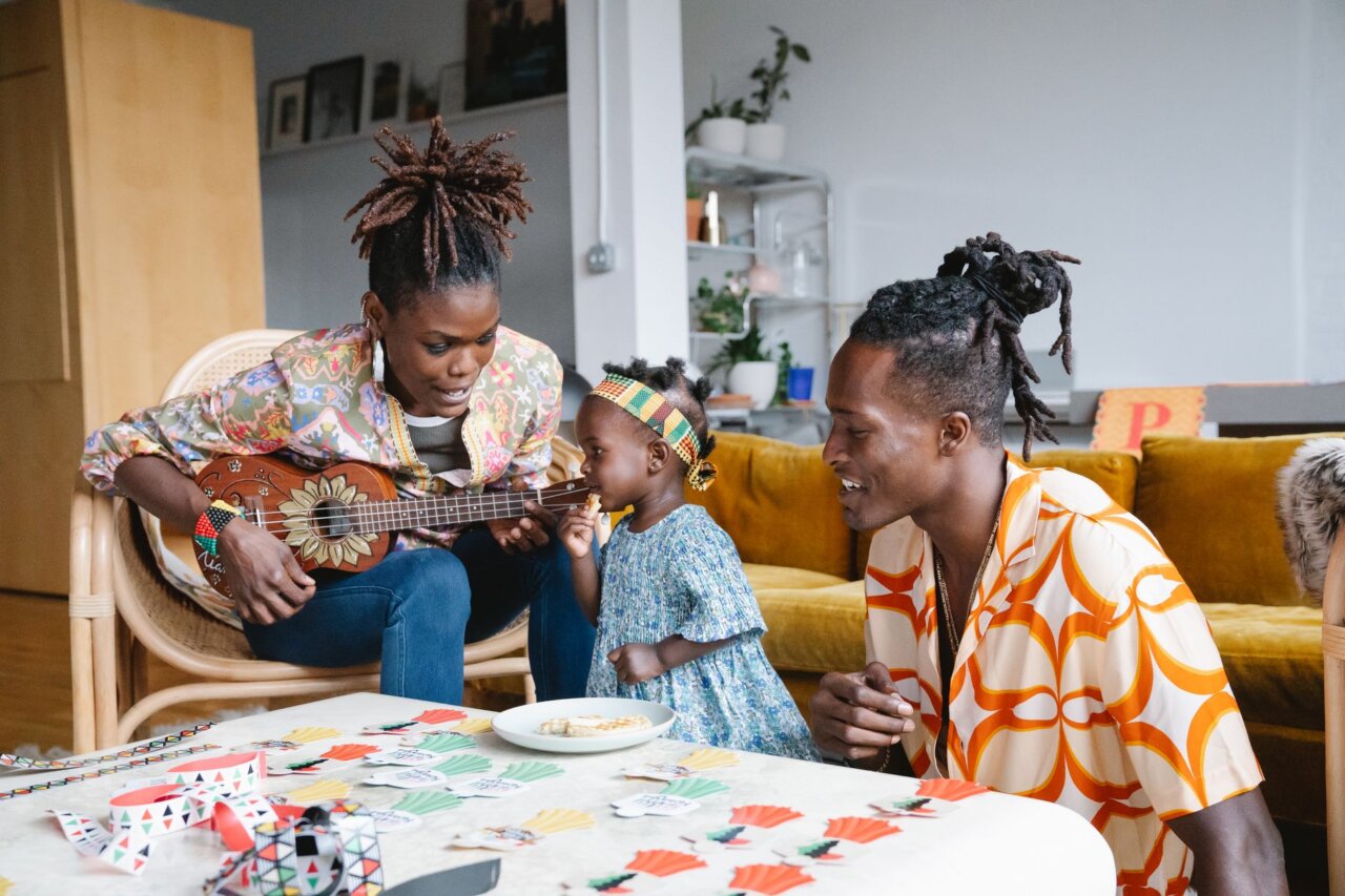 Parents and their child engaging together, exploring the features of the Yoto Music Box as they share a moment of laughter and creativity